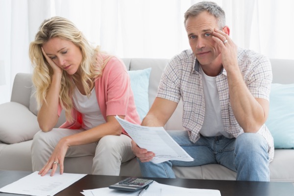 Adult couple distressed over paperwork at home